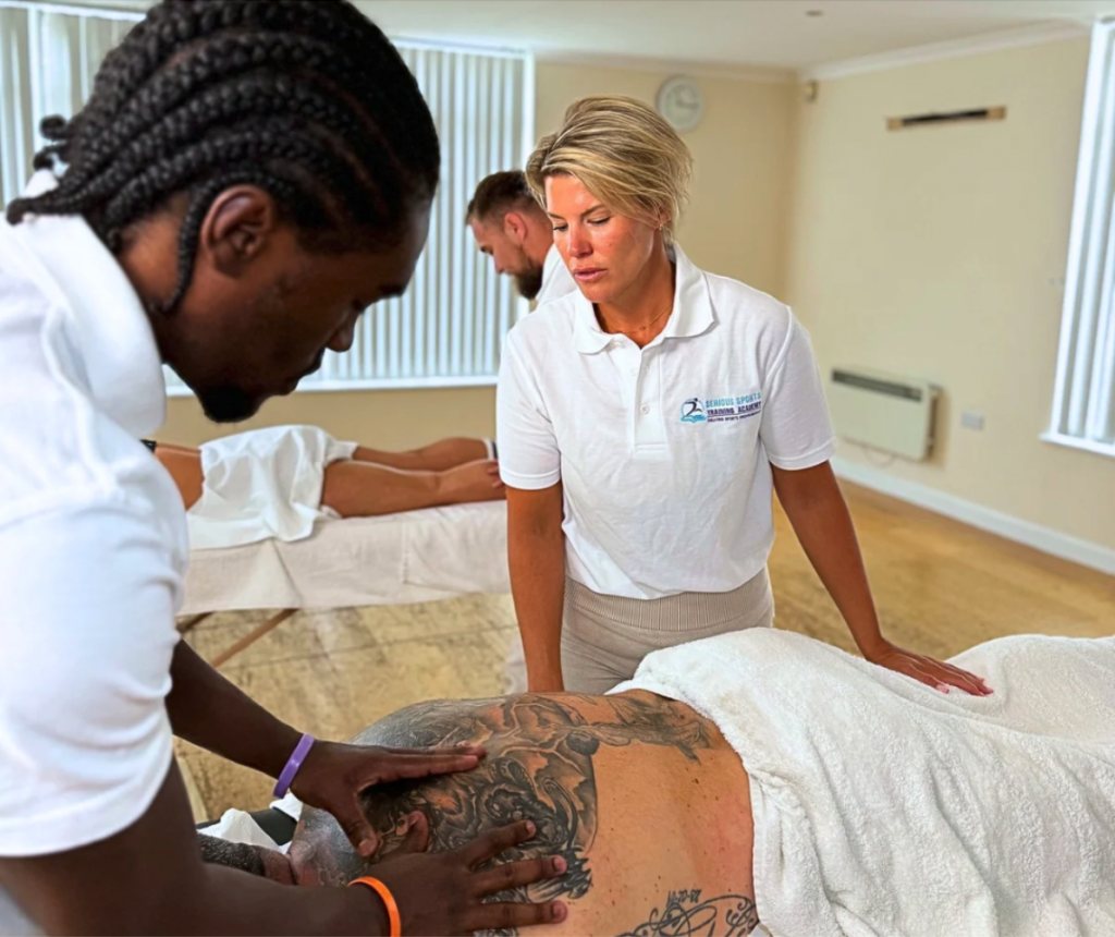 Tutor guiding learners through a hands-on sports massage session